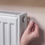 Venting the radiator. The man’s hand holds a special key which he inserts into the vent valve.