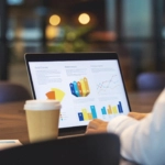 Close up of businessman using a laptop with graphs and charts on a laptop computer.